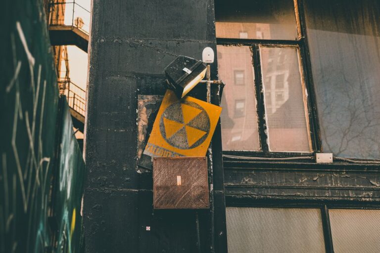 A person placing a radon test kit on a basement floor near an exterior wall.
